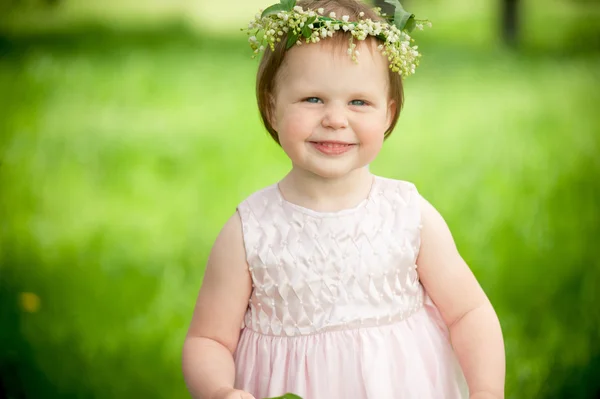 Dolce bambina in ghirlanda di fiori sorridenti all'aperto — Foto Stock