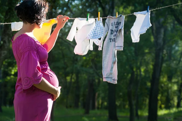 Mamma appende i vestiti del bambino su una corda — Foto Stock