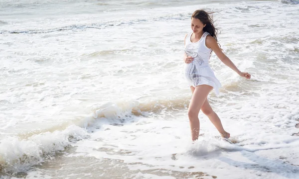 Belle femme enceinte tendre marchant sur le bord de la mer — Photo