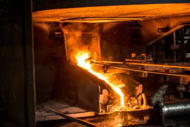 Yay fırınından sıvı metal dökülüyor. Çelik fabrikasında üretim süreci.