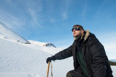 Karlı dağlarda buz baltası olan bir dağcı, portreyi yakından çekiyor.