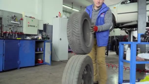 Worker Rolls Two Wheels Car Repair Shop — Stock Video