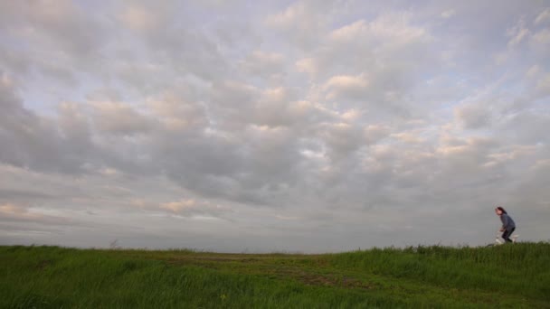 日落时小女孩骑自行车在风景秀丽的乡间路上 — 图库视频影像