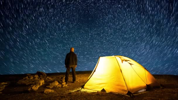 夜空の星の円の背景に輝くキャンプテントの近くの旅行者 シネマグラフとタイムラプス — ストック動画