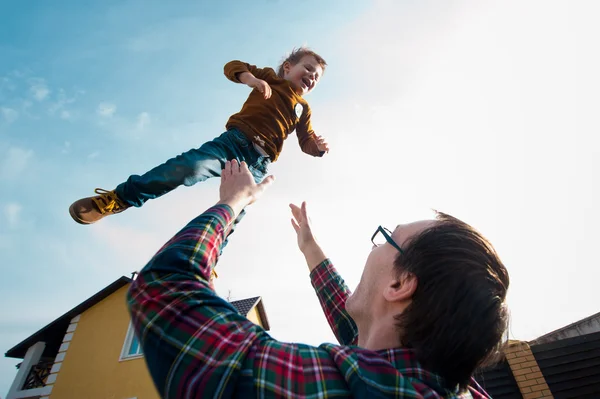 Člověk hodí chlapce na obloze — Stock fotografie