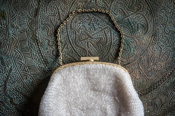 Embreagem feminina na bandeja de latão com um ornamento — Fotografia de Stock