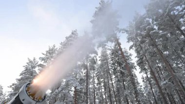 Kar silahı kış ormanına kar püskürtür..