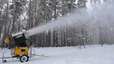 Kar silahı kış ormanına kar püskürtür..