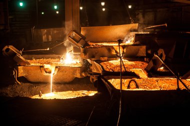 Ark ocağı üzerinden dökülen sıvı titanyum cüruf