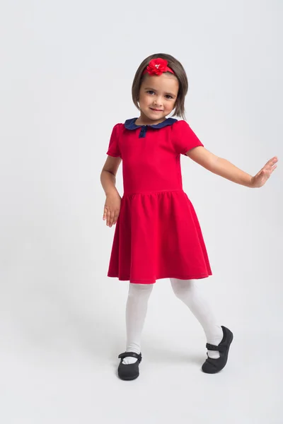Piękna dziewczynka uśmiechając się w czerwonej sukience — Zdjęcie stockowe