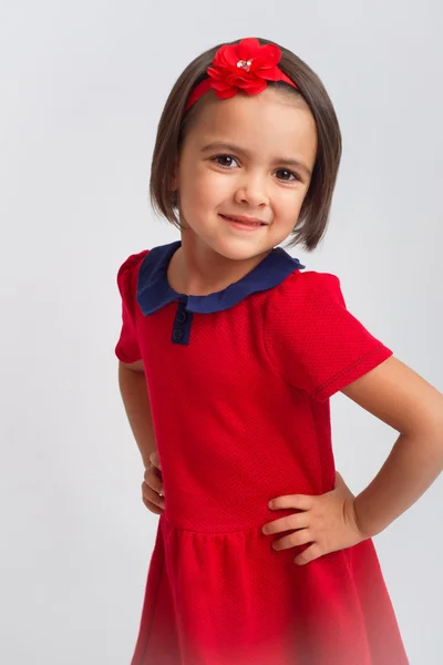 Piękna dziewczynka uśmiechając się w czerwonej sukience — Zdjęcie stockowe