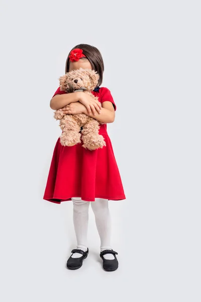 Κοριτσάκι με κόκκινο φόρεμα και αρκουδάκι. — Φωτογραφία Αρχείου