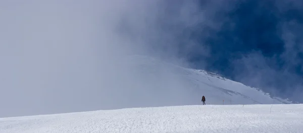 The man at the foot of a mountain peak in the clouds — Stock Photo, Image