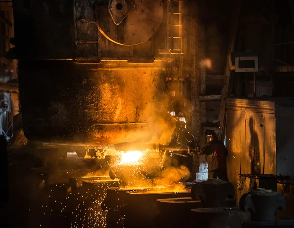 Steelworker pours liquid metal into molds from tank — Stock Photo, Image