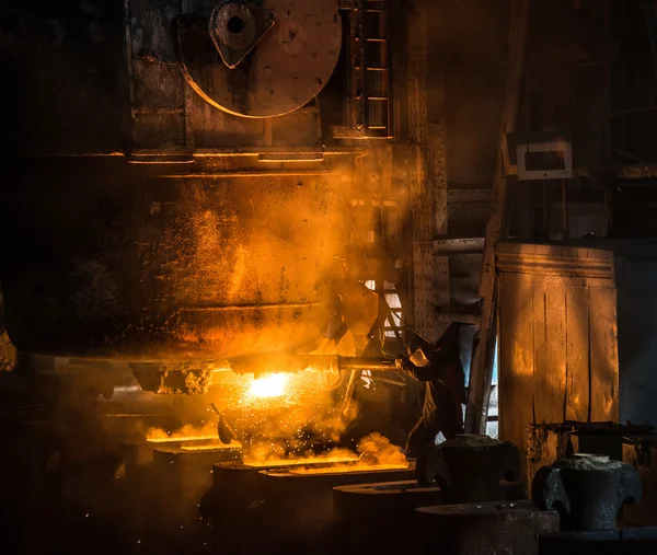 Steelworker vierte metal líquido en moldes del tanque — Foto de Stock