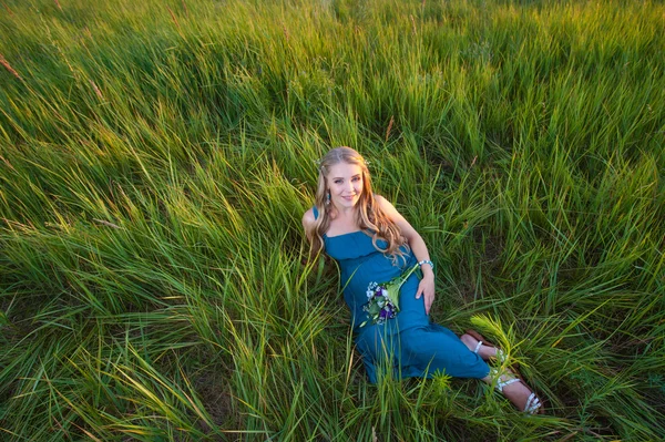 Sonriendo feliz embarazada acostada en la hierba — Foto de Stock
