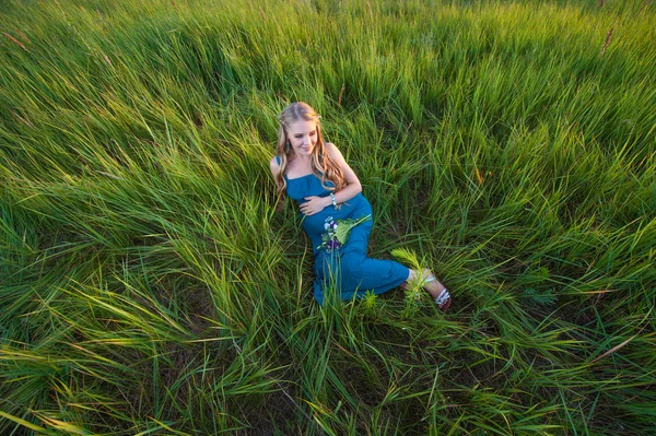 Usmíval se šťastný těhotná žena ležící na trávě — Stock fotografie