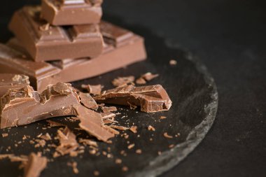 Koyu bir arka planda çikolata ve çikolata parçaları. Yüksek kalite fotoğraf
