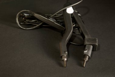 Siyah arkaplandaki saç uzatma maşaları. 