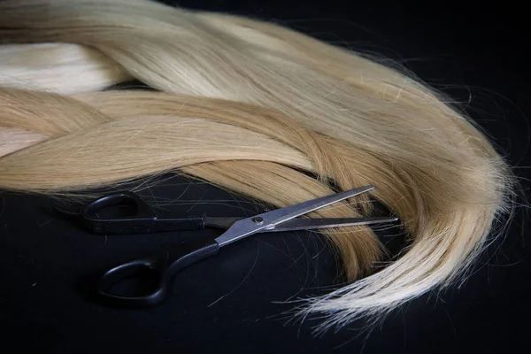 natural hair of different colors with scissors and comb. concept of hair care and hairdressing services.