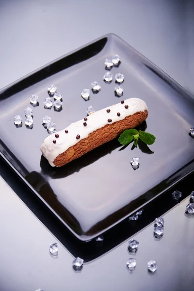 Exquisito postre de crema eclair con hojas de menta fresca — Foto de Stock