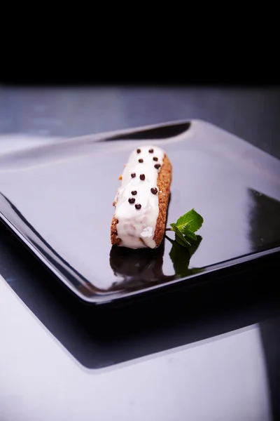 Exquisito postre de crema eclair con hojas de menta fresca — Foto de Stock