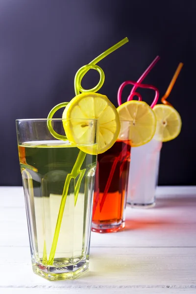 Tre frutta le bibite analcoliche con limone tubules su un orlo di un bicchiere. Calce a — Foto Stock
