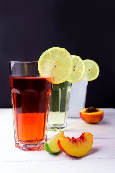 Drei Früchte-Erfrischungsgetränke mit Zitrone auf einem Glasrand. Kalk a — Stockfoto