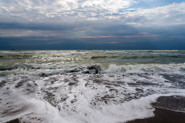 The sun's rays passing through the storm clouds over the sea 
