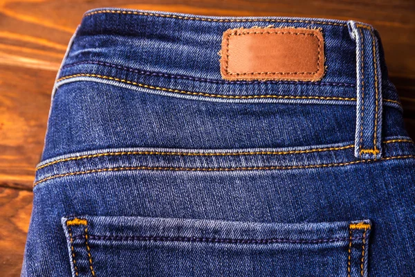 Blue jeans with half of back pocket and brown leather tag — Stock Photo, Image