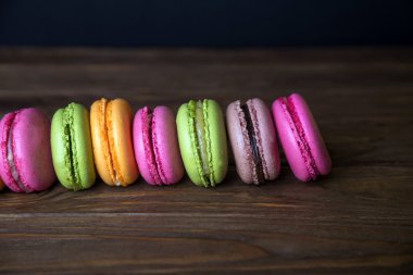 Fransızca macaroons ve koyu ahşap arka planda öğrendiklerinde