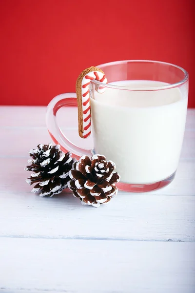 Galletas de Navidad con taza de leche sobre fondo rojo — Foto de Stock
