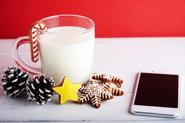 Christmas cookies with cup of milk at a red background