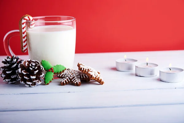 Galletas de Navidad con taza de leche sobre fondo rojo Fotos De Stock