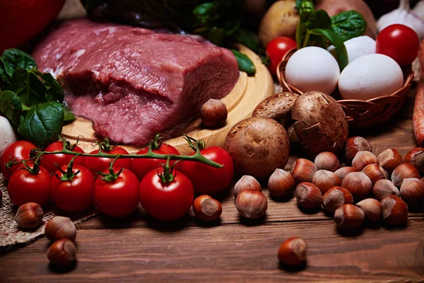 Nära syn på grönsaker och rått kött på en säckväv — Stockfoto
