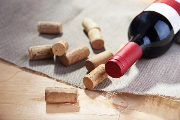 Vino y corchos sobre mesa de madera — Foto de Stock