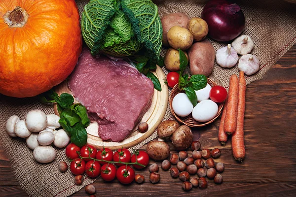 Frisches Gemüse und rohes Fleisch auf einem Sack — Stockfoto