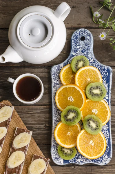 Frühstück Cracker mit Schokoladenpaste und Bananen, Kaffee und Obst — Stockfoto