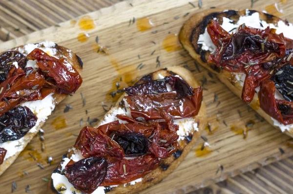 Bruschetta med fetaost och soltorkade plommontomater — Stockfoto