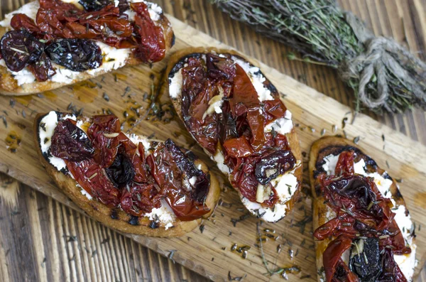 Bruschetta med fetaost och soltorkade plommontomater — Stockfoto