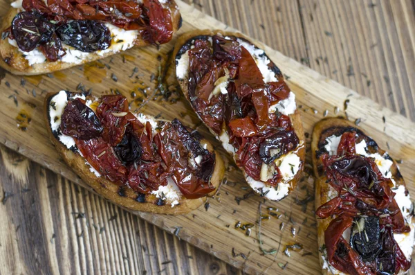 Bruschetta med fetaost och soltorkade plommontomater — Stockfoto