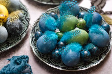 Paskalya masasında tüylerle boyanmış yumurtalar.  