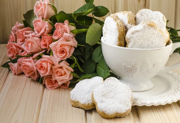 Spanish cookies for fat in a cup with a bouquet of roses — Stock Photo, Image