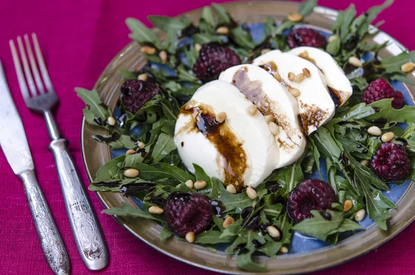 Arugula salad with mozzarella raspberries pine nuts — Stock Photo, Image