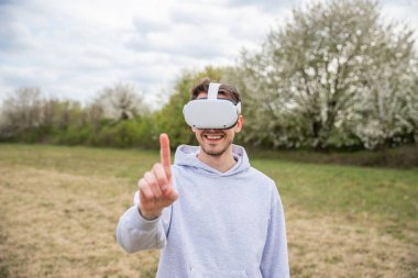Tarladaki bir adam dışarıda VR kulaklıkları takarken eğleniyor..