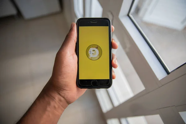 Üzerinde Dogecoin logosu olan akıllı telefon, geleneksel bankacılık ücretlerinden muaf bir ödeme sistemine sahip olmak için yaratılmış çok popüler bir kripto para birimidir.
