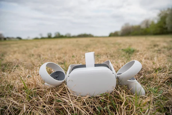 Oculus Seferi 2. Sanal gerçeklik kulaklığı, kumandalı, çimlerin üzerinde dinleniyor.