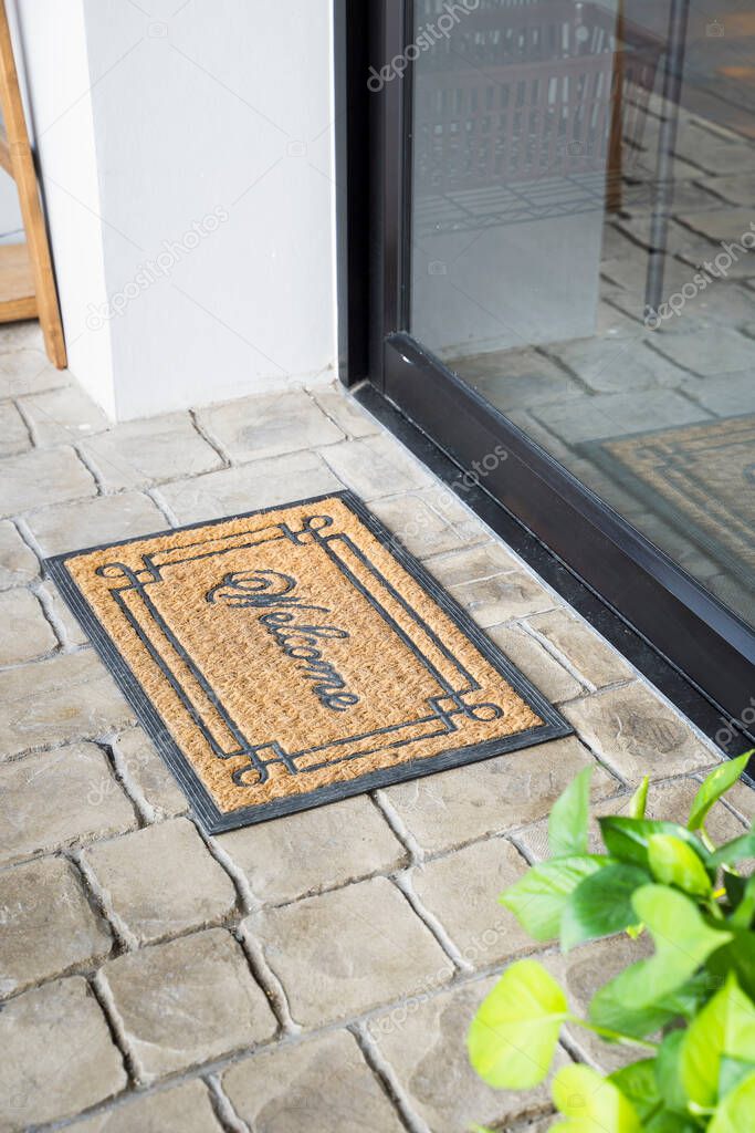 View of welcome mat outside inviting in front of door house