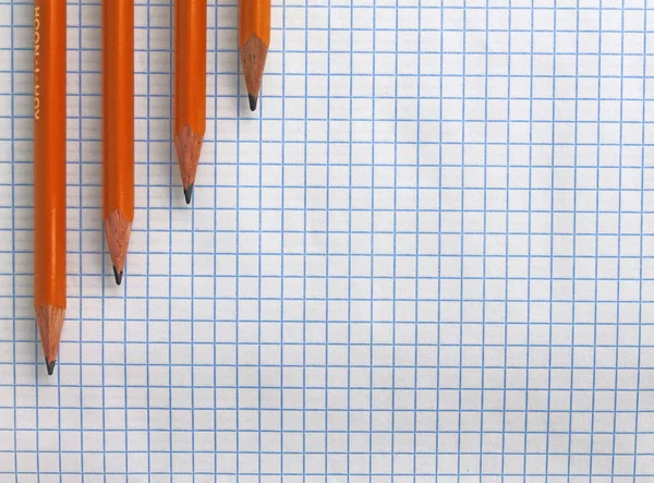 Lápices en una hoja de cuaderno blanco — Foto de Stock