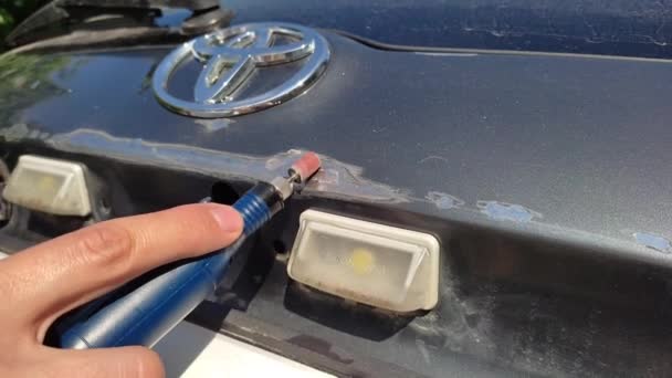 Kemerovo, Rússia, 14-09-2021: Eliminação de manchas enferrujadas no carro Toyota com a ajuda de uma máquina de manicure, reparo do corpo com suas próprias mãos — Vídeo de Stock